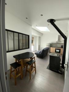 a living room with a table and chairs and a stove at Chalet appartement Chanac 2 chambres 2 sdb wifi gratuit in Chanac +6 photos