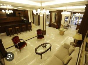 uma sala de estar com um sofá e cadeiras em Taj suite hotel em Al Qanţārī