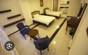 um quarto com duas camas e duas cadeiras e uma mesa em Taj suite hotel em Al Qanţārī