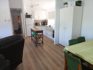 a living room with a table and a kitchen at Palm Grove Holiday Home in Agnes Water