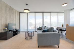 a living room with a couch and a television at Avenue 201 2 BED in Paphos