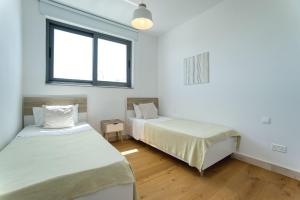 a bedroom with two beds and a window at Avenue 201 2 BED in Paphos +10 photos
