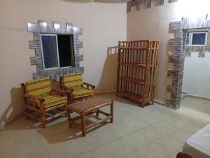 a room with chairs and a table and a window at Nyantanto Eco Lodge in Gunjur