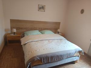 a bed in a bedroom with two night stands and two lamps at Gîte Hecker Alsace in Niedersteinbach