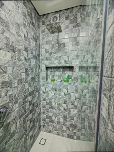 a bathroom with a shower with a stone wall at AH/Loft panorámico, Cama Queen, Coworking-Parking in Bogotá +49 photos