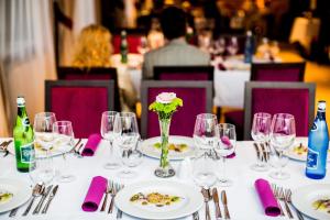 stół z talerzami i okularami oraz wazon kwiatów w obiekcie Cottonina Hotel & Mineral SPA Resort w Świeradowie Zdroju