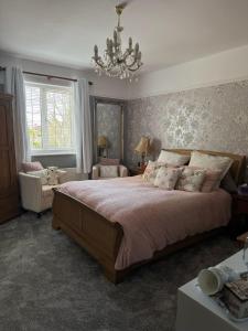 a bedroom with a large bed and a chandelier at West ave exeter in Exeter