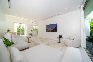 PhuketにあるCoco Villas Phuket - Private Pool Villas by Escape Villasの白い壁のリビングルーム(白い家具付)