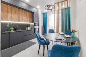 Красотка в сером في أستانا: مطبخ وغرفة طعام مع طاولة وكراسي زرقاء