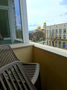 einen Balkon mit einer Bank und Blick auf ein Gebäude in der Unterkunft Golden Light - 3BR Luxury Central in Bŭnzareto