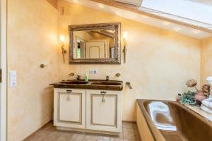 une salle de bain avec un lavabo et un miroir dans l'établissement Großes Ferienhaus mit Bergblick, à Unterwössen 25 autres photos