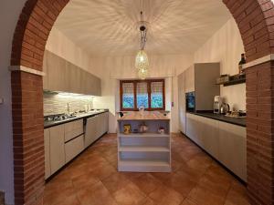 a large kitchen with an archway in a building at Villetta la Fortezza Oasi Verde e Relax Toscano in Radicofani