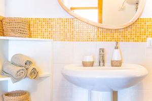 a bathroom with a sink and a mirror and towels at Attico Orizzonte, splendida vista sul golfo IUN T2810 in Cala Gonone +33 photos