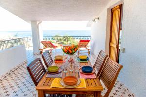 a wooden table with a vase of flowers on a balcony at Attico Orizzonte, splendida vista sul golfo IUN T2810 in Cala Gonone