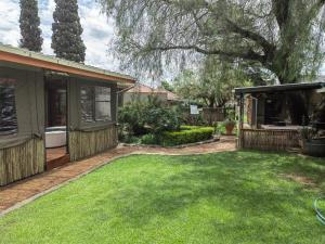 a backyard with a house and a yard with green grass at Sibahlenomhlambi Guesthouse in Springs
