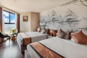Cette chambre comprend deux lits et un dessin mural. dans l'établissement Mandala Pearl Resort, à Mui Ne 71 autres photos