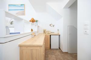 cocina con paredes blancas y encimera de madera en Sand Beach House, Naxos Stelida, en Stelida