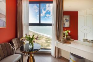 un salon avec une grande fenêtre avec vue sur l'océan dans l'établissement Mandala Pearl Resort, à Mui Ne