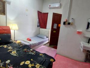 Una pequeña habitación con dos camas y un lavabo. en Cassa Bonda Standard Double Room, en Macang 38 fotos más