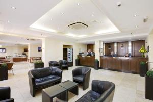 um lobby de um hospital com cadeiras e uma sala de espera em Queens Park Hotel em Londres