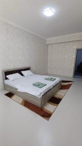1 dormitorio con cama blanca y alfombra en el suelo en Бухара Олд Сити, en Bukhara
