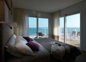 1 dormitorio con 1 cama y vistas al océano en Hotel Le Soleil, en Lido di Jesolo