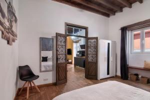 a bedroom with wooden doors and a chair in it at El Rincon Del Viajero Gran Canaria in Santidad