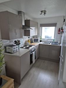 a kitchen with a sink and a stove top oven at Roma's Retreat chalet, Hemsby in Hemsby +10 photos