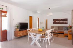 a living room with a table and chairs and a television at Ca N'Alicia Des Bosch in Illes Balears