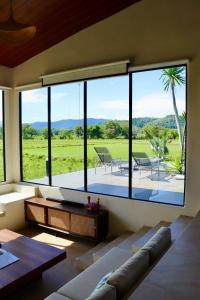 Langkawi IntlにあるVilla Moo Moo, Pool Villa with Sunset & Paddy Field Viewsの大きなガラス窓付きの広いリビングルーム