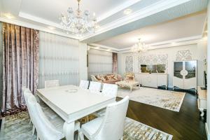 comedor y sala de estar con mesa blanca y sillas en Luxury AMOR Sea View Apartment 33, en Baku