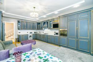 cocina grande con armarios azules y mesa en Luxury AMOR Sea View Apartment 33, en Baku