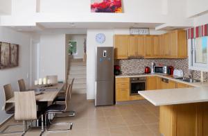 a kitchen with a table and a stainless steel refrigerator at Villa Roda Park Corfu in Roda