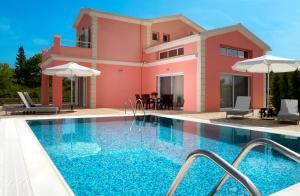 a villa with a swimming pool in front of a house at Villa Roda Park Corfu in Roda