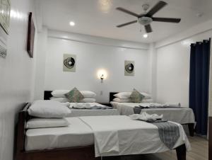 a room with three beds and a ceiling fan at Sunvilla beachfront hotel in Boracay +20 photos