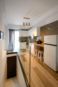 una grande cucina con frigorifero bianco e pavimenti in legno di Petite Maisonnette at Garitsa! a Corfu International Airport I Kapodistrias Altre 25 foto