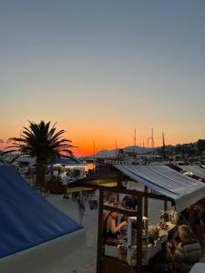 a group of people sitting at a market at sunset at Bilenjki Apartments in Baška Voda +5 photos