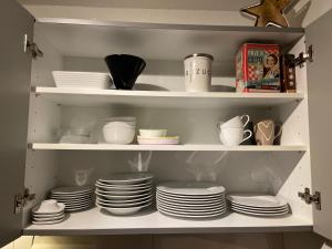 a cabinet filled with plates and cups and dishes at Almblick Ferienwohnung in Balderschwang +17 photos