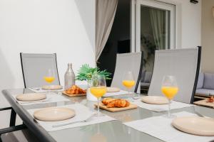 una mesa de comedor con vasos de zumo de naranja y cruasanes en Villa Brisamaré I Private Pool I Free parking, en El Verger