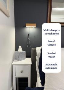 a room with a bed and a table with a box of tissues at The Chapel - Worcester City - FREE Parking, WI-FI, Toiletries - TVs in rooms - Stocked kitchen - Entire Apart - Self Check-In - Outside Space in Worcester