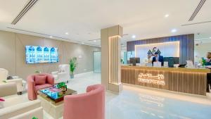 a lobby with a reception desk and pink chairs at Diafat AlSaadah Serviced Apartments- Qurtopa 2 in Riyadh