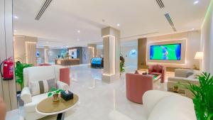 a lobby with white furniture and a flat screen tv at Diafat AlSaadah Serviced Apartments- Qurtopa 2 in Riyadh