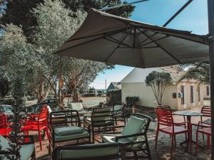 un grupo de sillas y mesas con sombrilla en VVF Golfe du Morbihan Sarzeau Arzon, en Sarzeau 15 fotos más