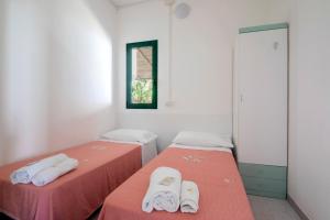 two beds in a room with red and white sheets at Camping Villaggio Il Frutteto in Cupra Marittima +16 photos