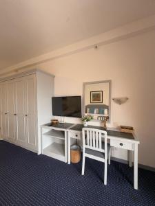 a room with a desk with a computer and a tv at Rainbow Paradise Resort by Achlys Collection in Tanjung Bungah