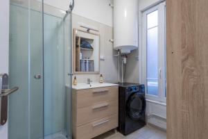 a bathroom with a sink and a washing machine at Graziella front de mer in Mers-les-Bains