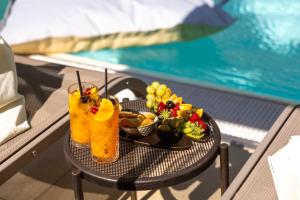 a tray of fruit and drinks on a table next to a pool at MySEELE Garda Active Hotel in Nago-Torbole
