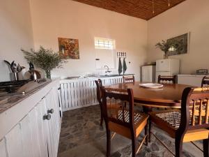 a kitchen with a wooden table and a kitchen with a refrigerator at De Rustica Stable Stay in De Rust