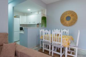 a living room with a table and chairs and a kitchen at Panther Home Islantilla Deluxe in Isla Cristina +11 photos