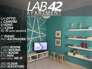 copertina di una rivista con una stanza con TV e sedie di LAB42 City & San Matteo Apartment - 2 Bedrooms a Pavia